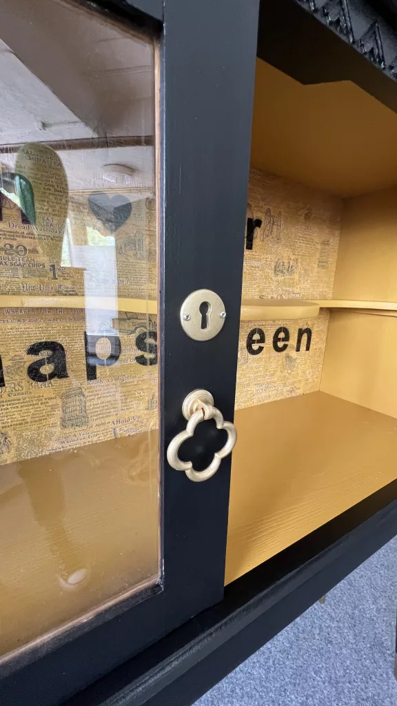Blick durch Schnappslottes Glastür auf das goldene Innenleben mit Schriftzug