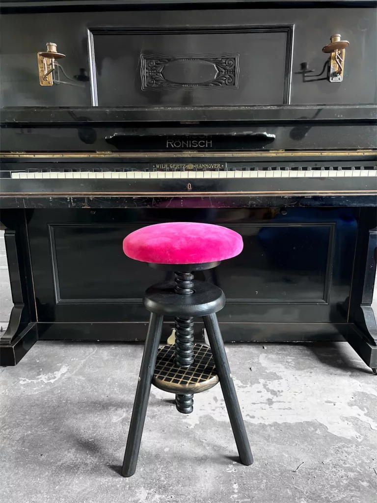 Polly am Klavier, schwarzes Gestell und pinker Samtsitz