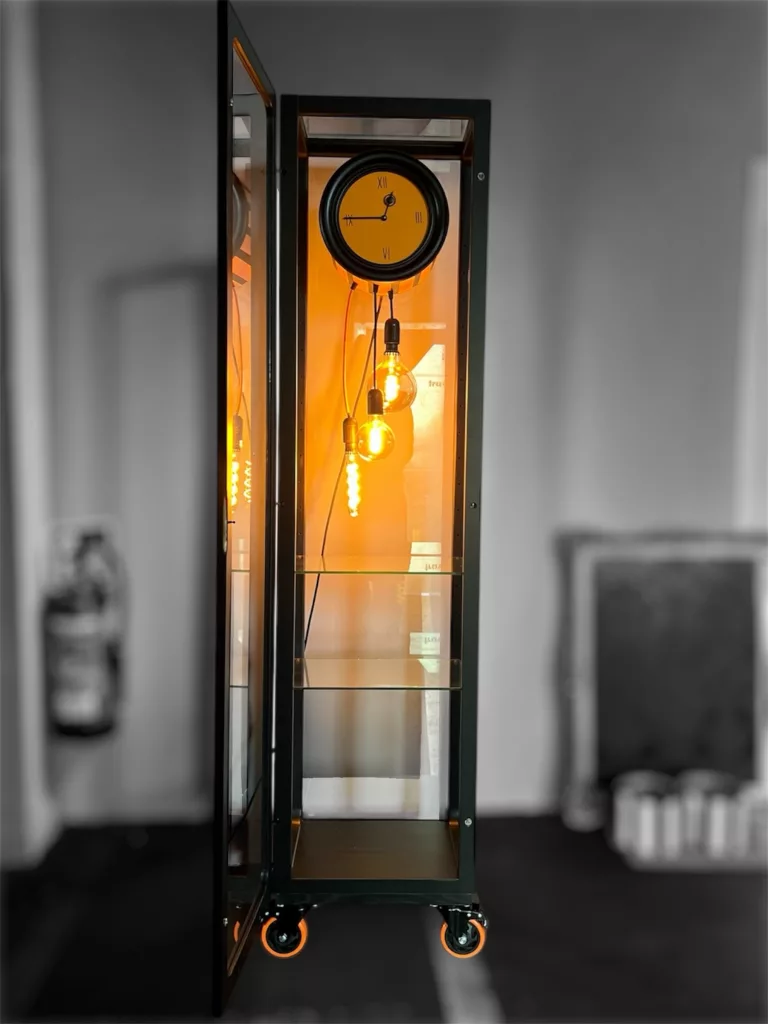 Senta im Raum: 1,85 Meter hohe Vitrine mit Uhr, Licht und Rollen