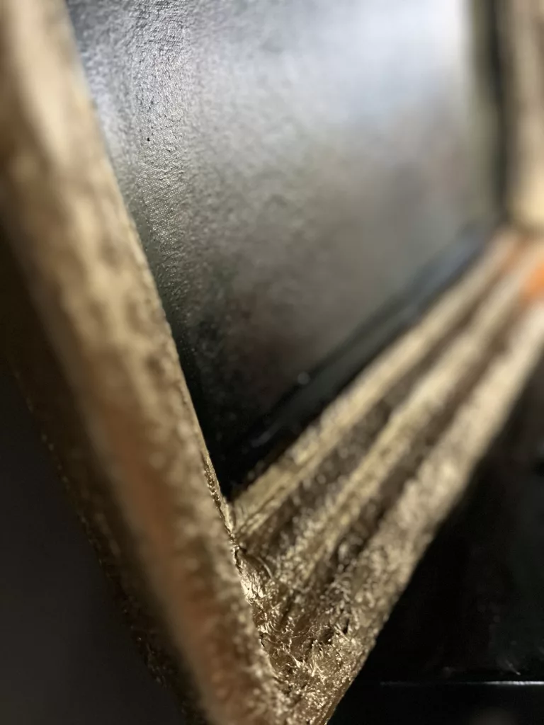 Detail der Rahmenecke von Mona Mona Inked, abgeriebenes Gold auf dunklem Grund
