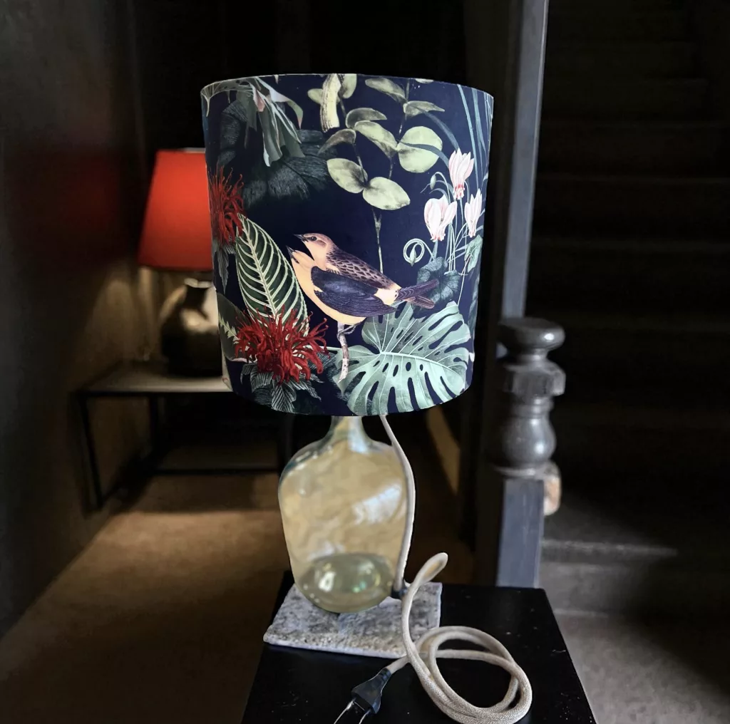 Flaschenlampe mit dunkelblauem Blattmuster-Schirm auf einer Glasballon-Flasche