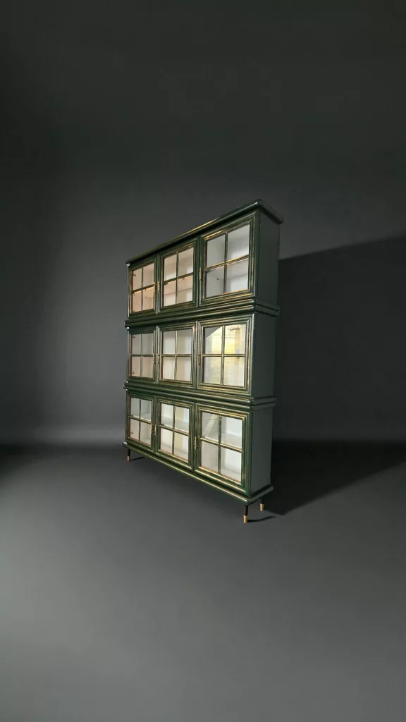 Theodor schräg von links, hohe grüne Vitrine mit vielen Glasfeldern