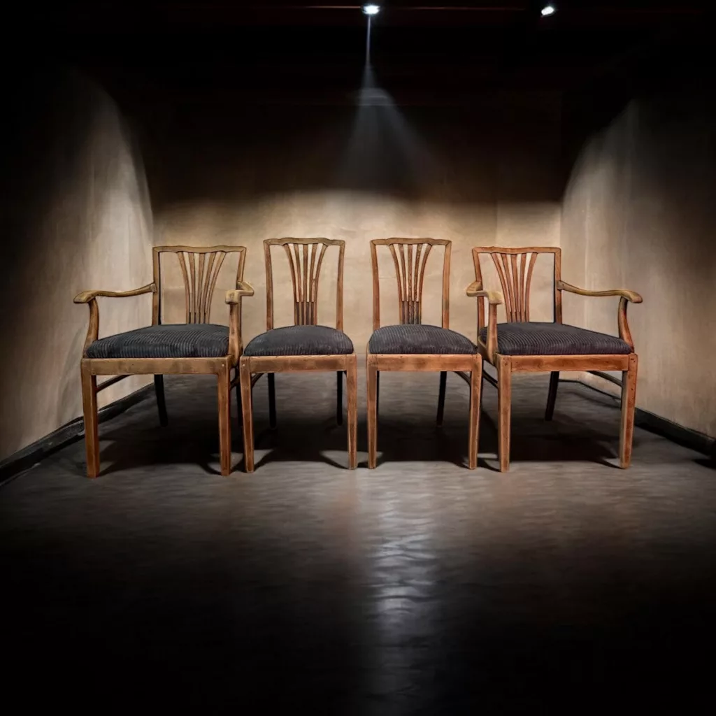 Die Sitz-Philosophen: vier aufgearbeitete Holzstühle nebeneinander im Licht