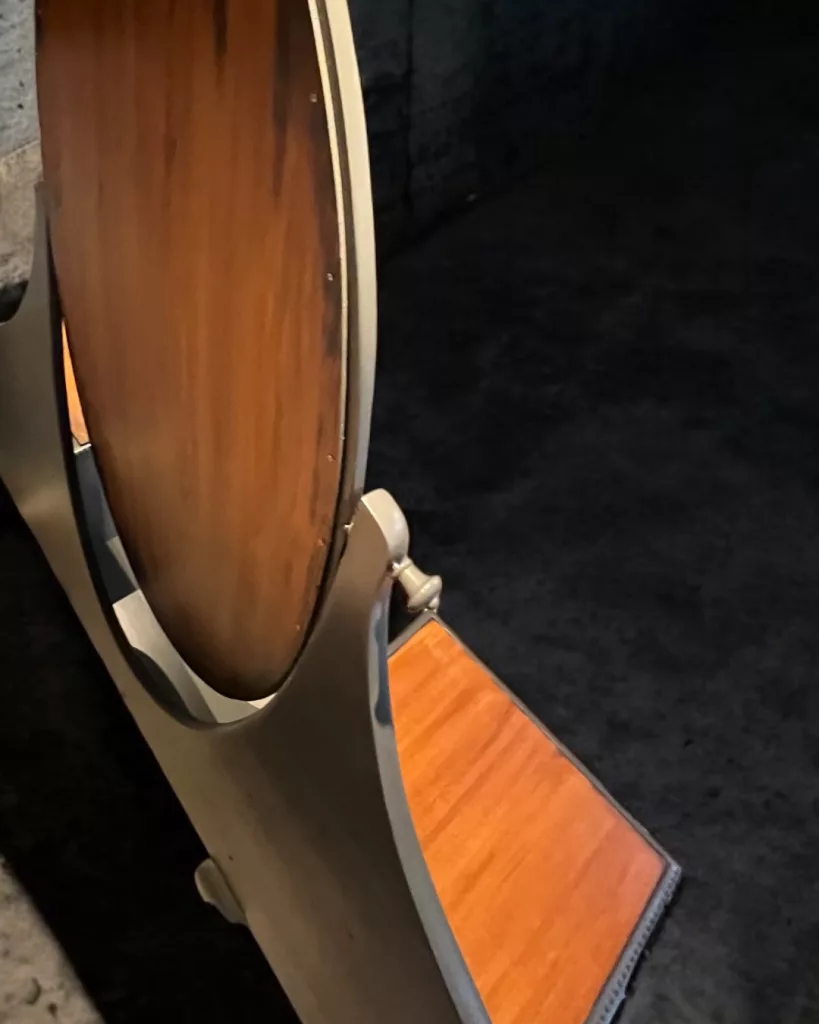 Detail: Spiegelkante über der orangefarbenen Holzablage