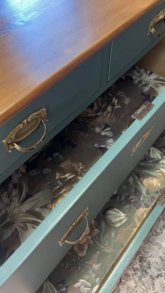 Geöffnete Schubladen mit floral tapeziertem Boden