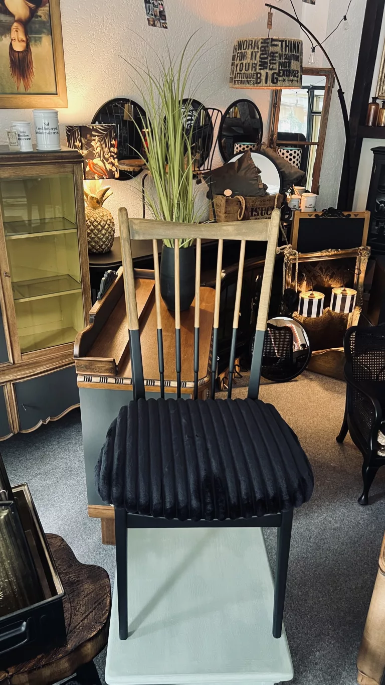 Ausstellungsraum mit Vintage-Stuhl, Vitrinen und Bilderwand bei Pottschön in Hemer