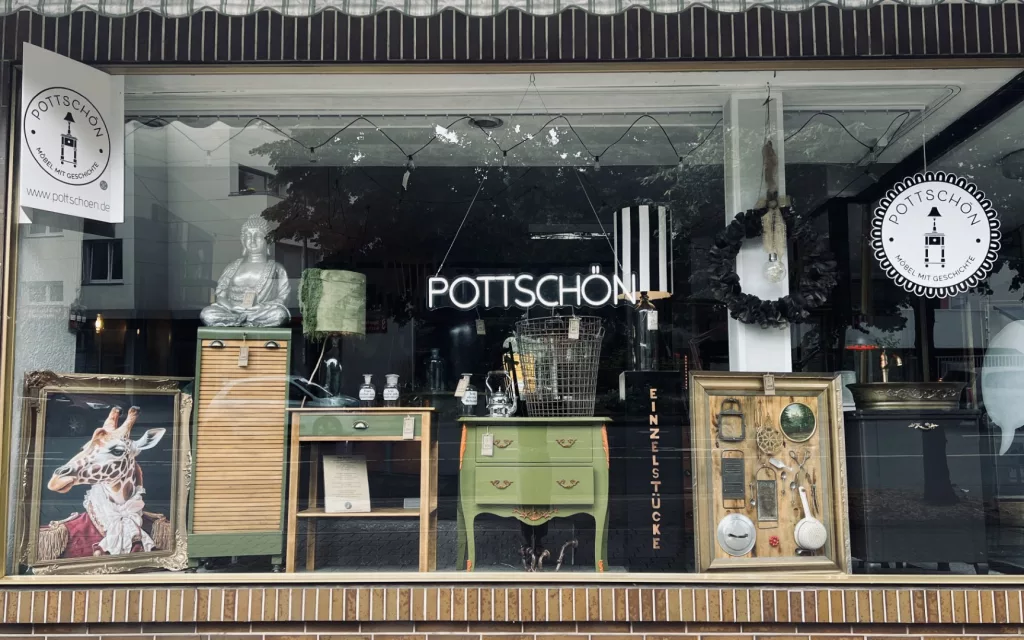 Beleuchtetes Schaufenster von Pottschön in Hemer mit restaurierten Vintage-Möbeln